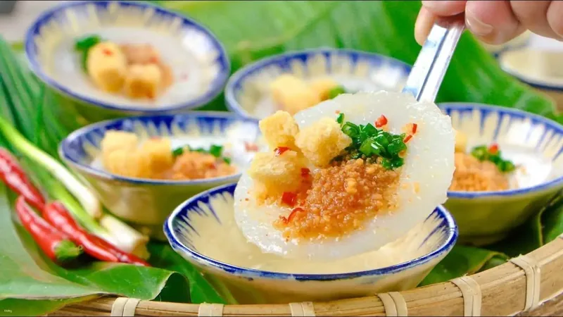 Steamed rice cakes topped with fried shallots, scallions and chili in blue-rimmed dishes, a specialty of Hue.