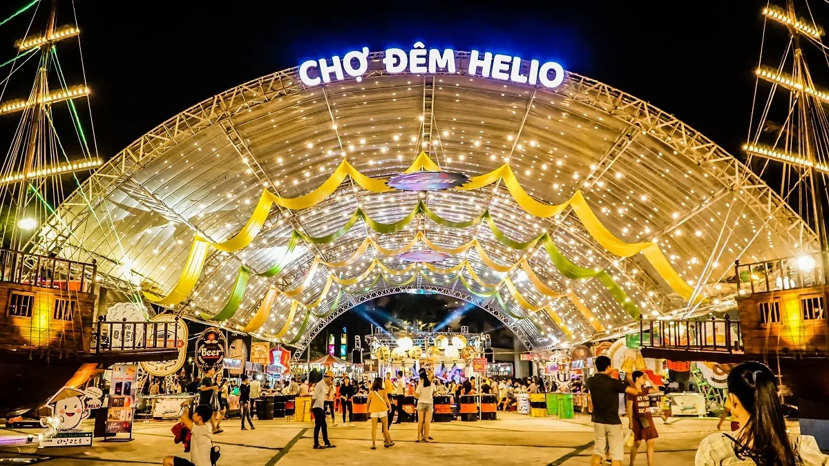 Illuminated arched roof and colorful stalls at Cho Dem Helio night market in Da Nang after dark.